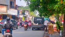Pedagang buah di trotoar Jalan Kali Baru Timur tampak menurunkan buah dari mobil ke lapak dagangannya