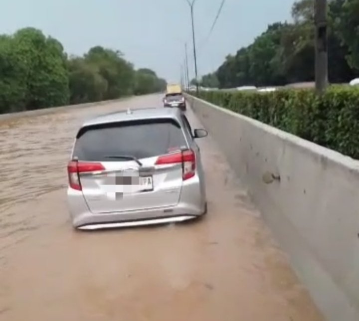 Hujan deras menyebabkan kali sabi meluap ke tol Jakarta Tangerang menyebabkan banjir dan  Kemacetan di KM 24 arah Jakarta dan arah Tangerang, foto tangkapan layar pengguna jalan tol