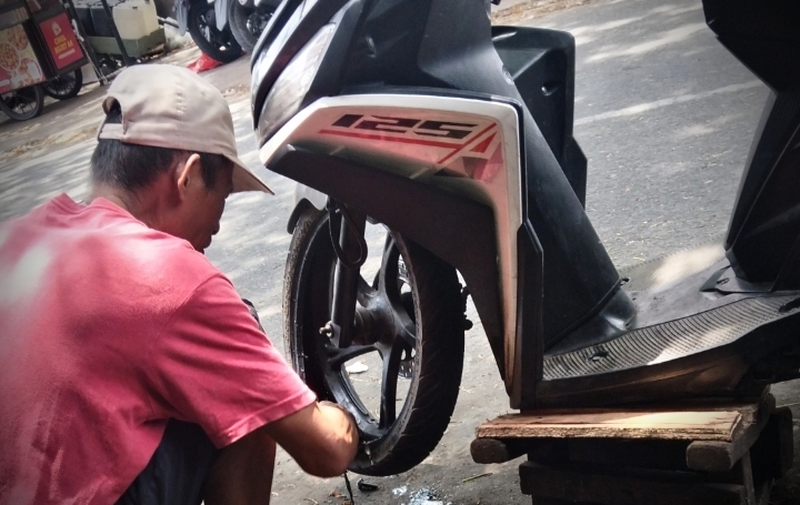 Tukang tambal ban, Mang Jun, mengungkapkan bahwa penyebab paling umum ban kempes adalah tertusuk benda tajam seperti paku atau kawat